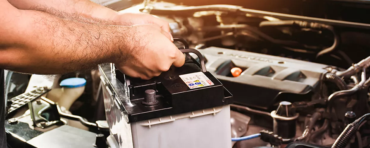 Service mechanic changing a car battery