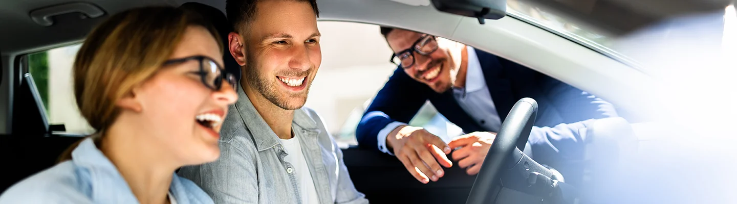 salesman talking a couple in their car