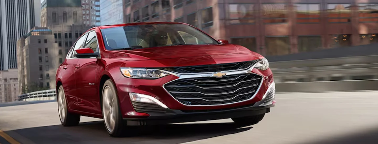 Front view of a 2024 Chevrolet Malibu driving in the city
