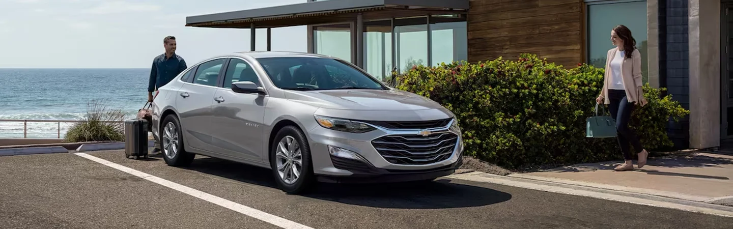 A gray 2024 Chevrolet Malibu parked in a driveway