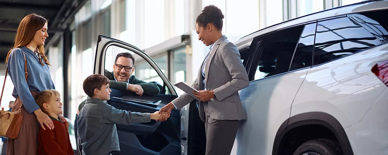 Car salesman showing a family a new vehicle in a Mercedes-Benz dealership