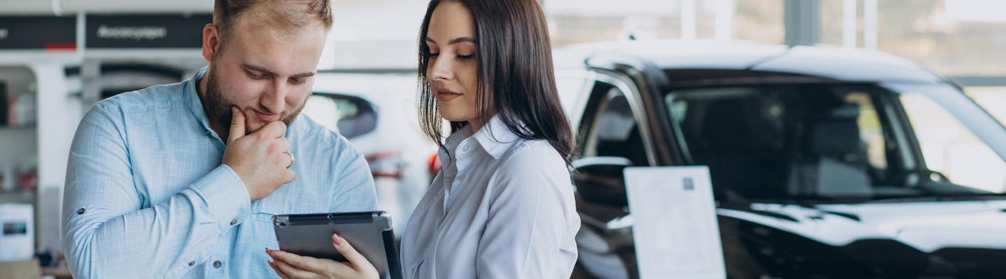 Dealership employee showing a customer something on their tablet