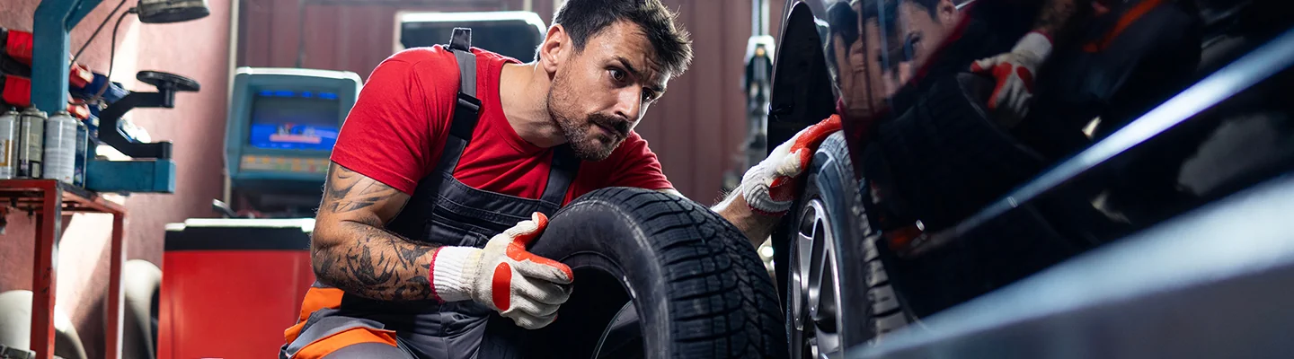 Mechanic changing tire on vehicle