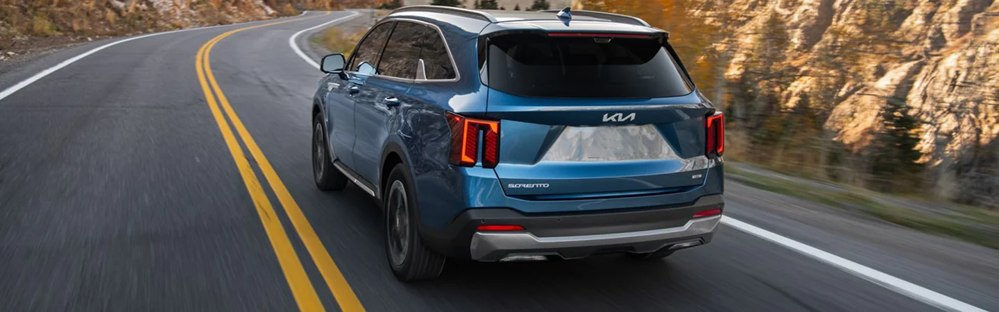 Back view of a 2025 Kia Sorento Hybrid driving on a road