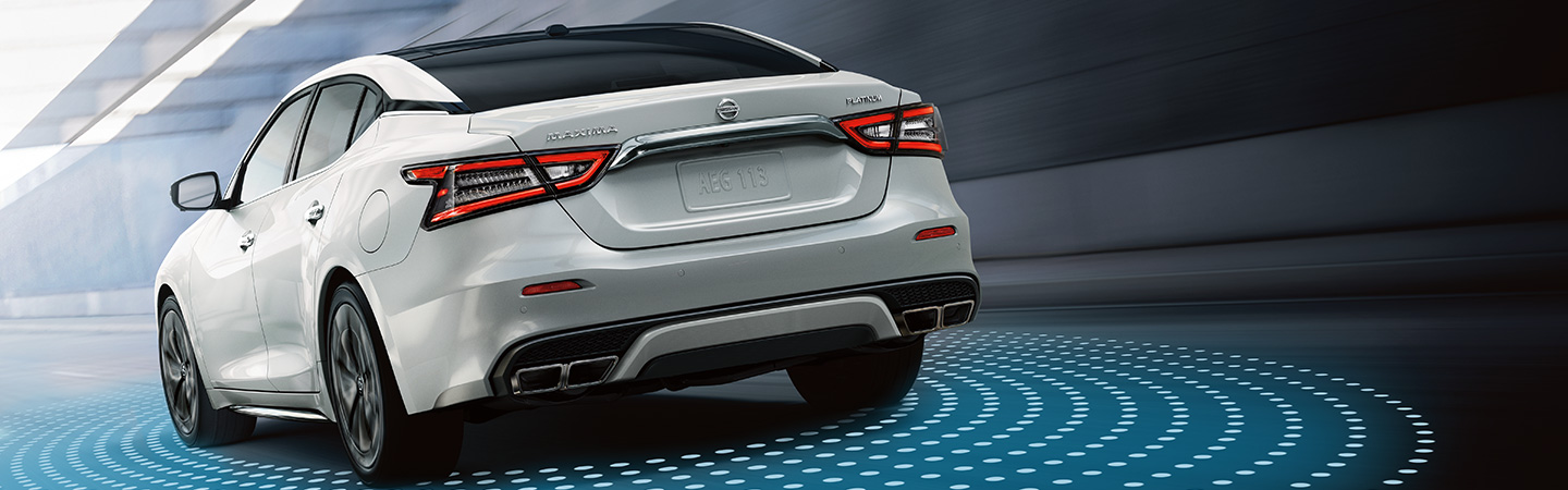 rear of white maxima driving away