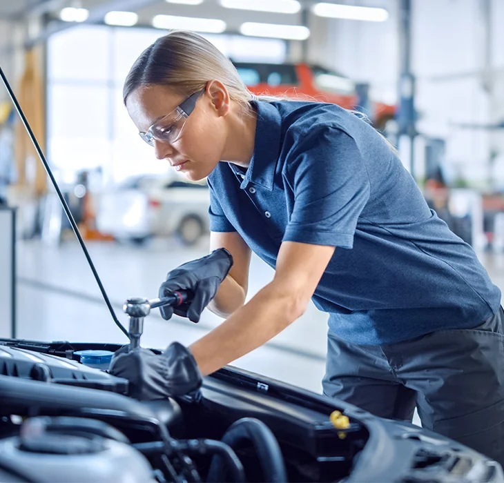 mechanic in the shop room running a diagnosis of a vehicle on the computer