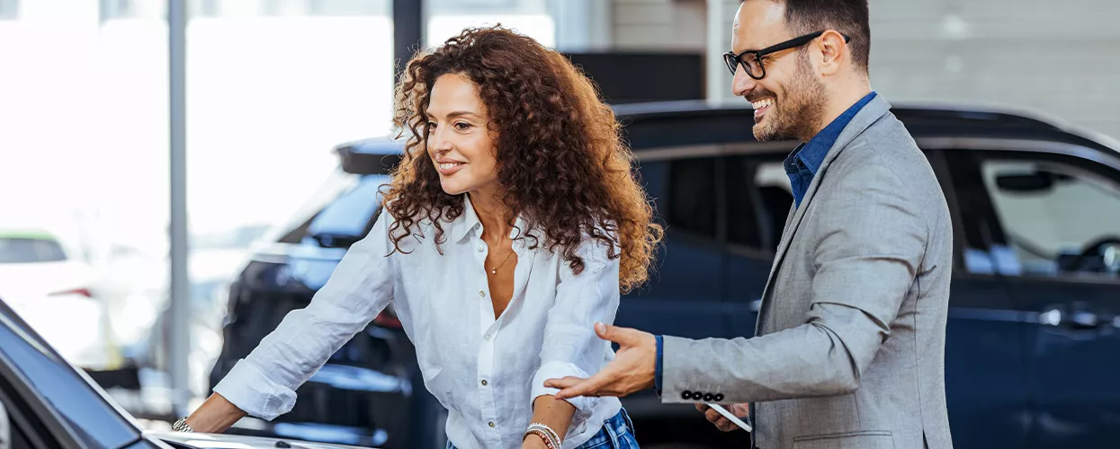 Car salesman showing a customer a new vehicle