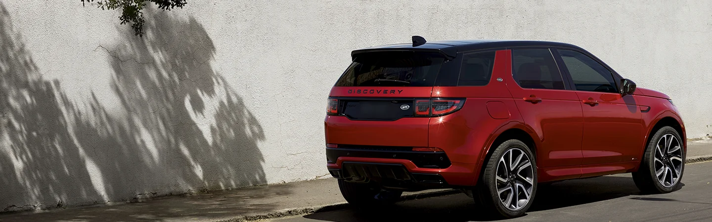 red 2025 Discovery Sport S parked next to a large white wall