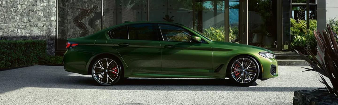 Side view of a green 2022 BMW 5 Series parked