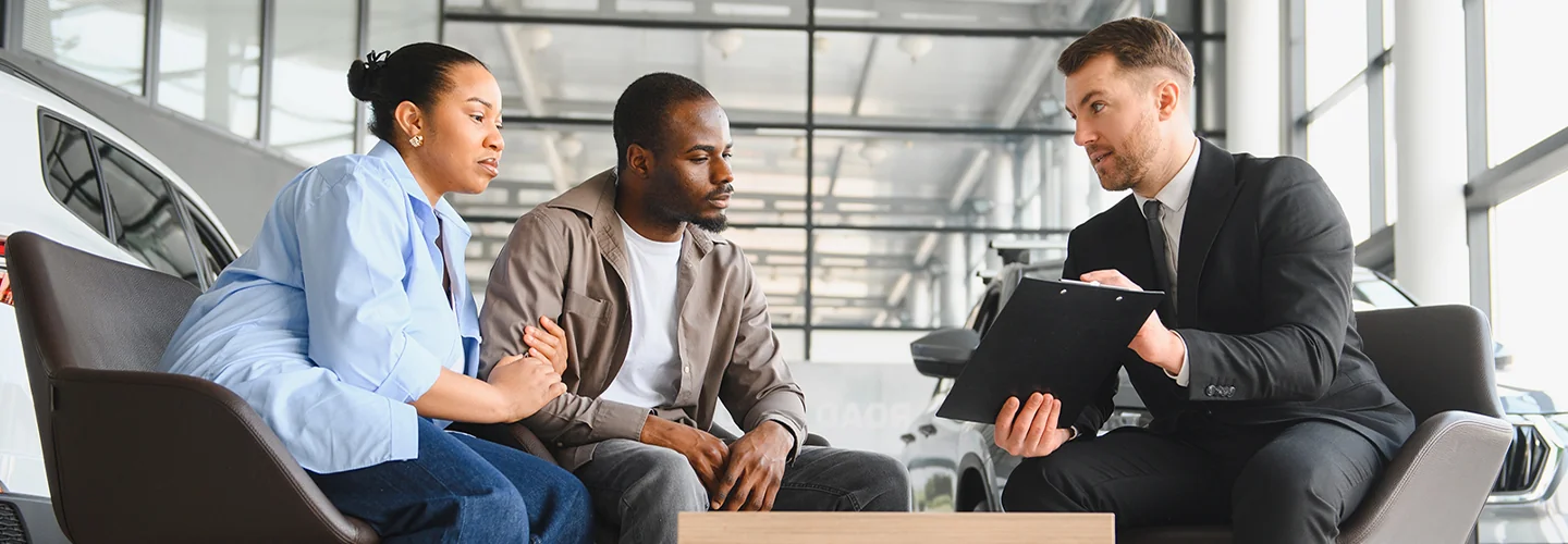 Sales person talking to customers about there Kia Hybrid lineup