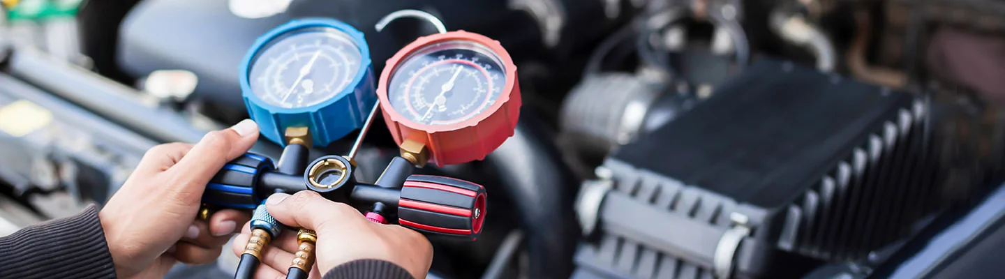 auto mechanic pouring oil into engine