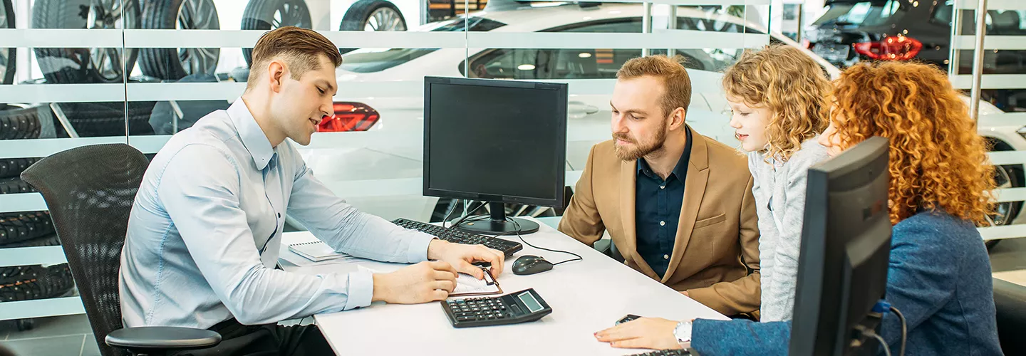 Family talking to a car salesman about a contract