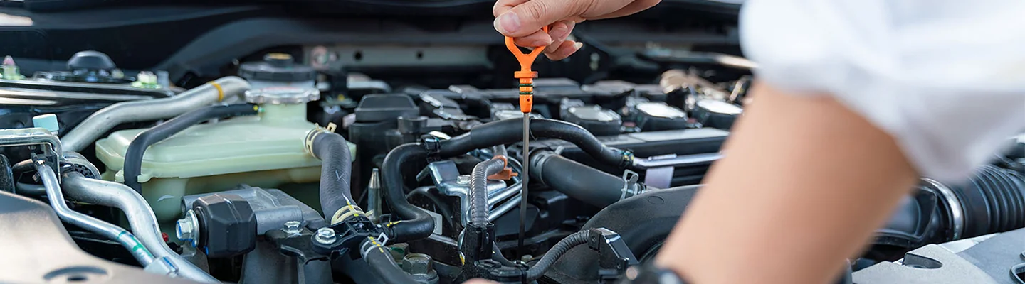 Volkswagen service tech checking the oil on a car