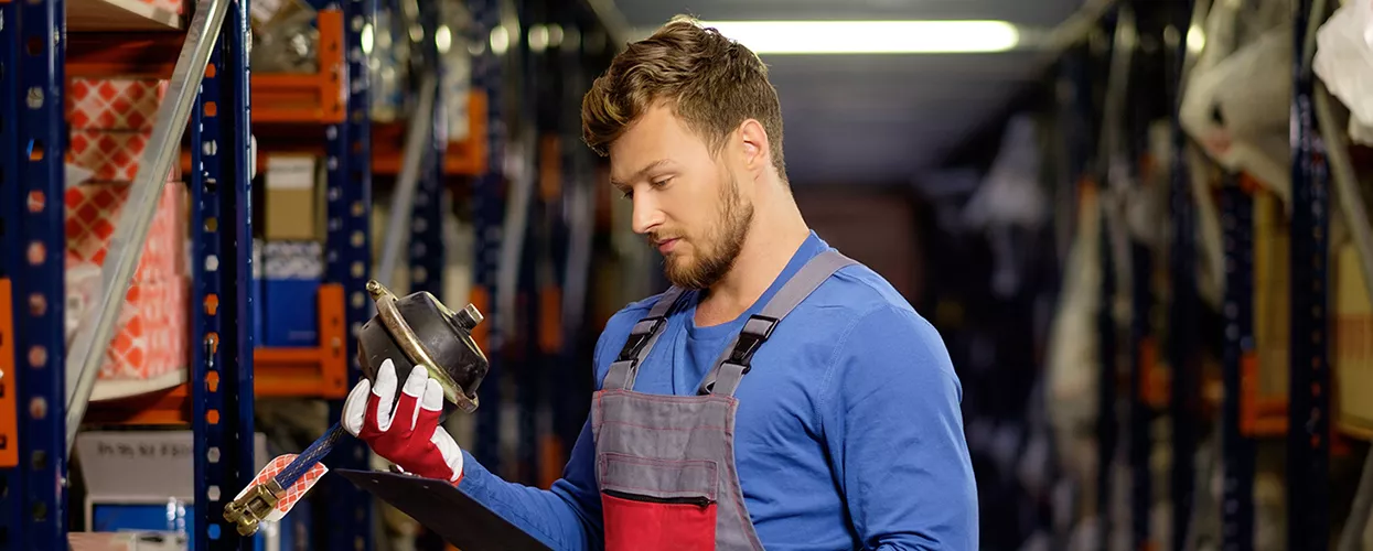 Service mechanic looking at a car part