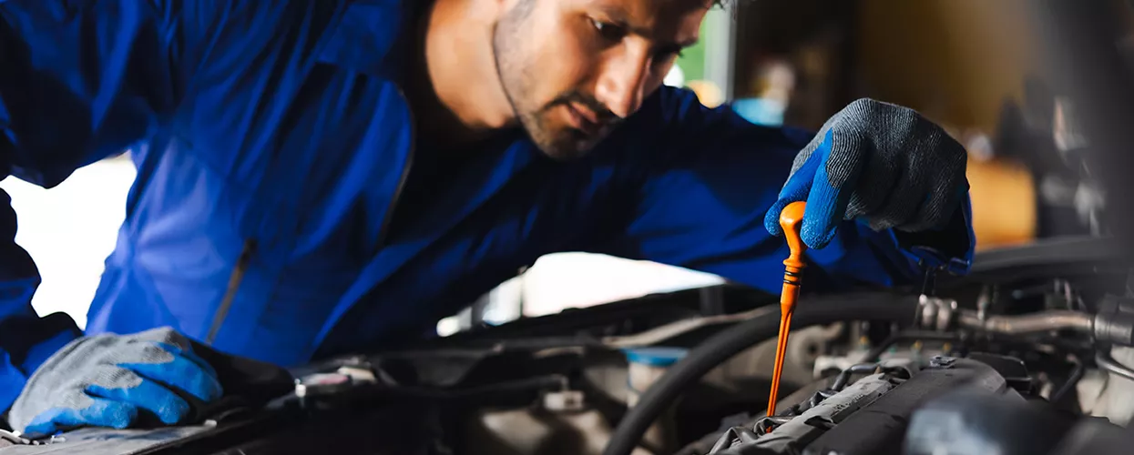 Service mechanic working under the hood of a car