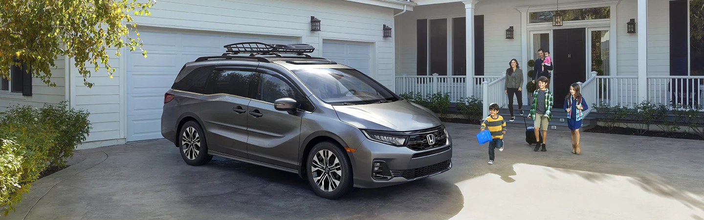 2025 Honda Odyssey EX-L parked out side house with many people about to board