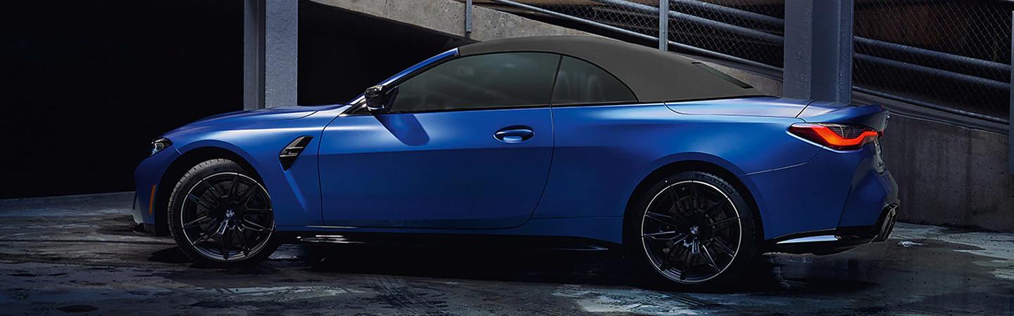 Blue 2022 BMW M4 in parking garage at night