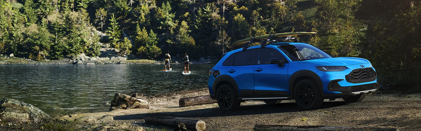 A blue 2026 Honda HR-V parked at lake with people paddle boarding