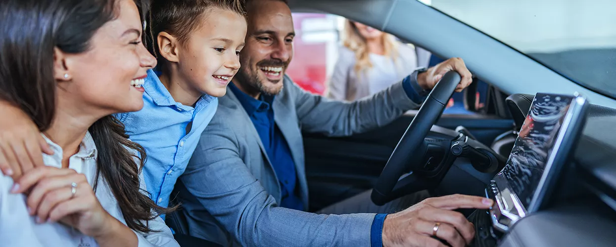Family looking at a new vehicle in a car dealership