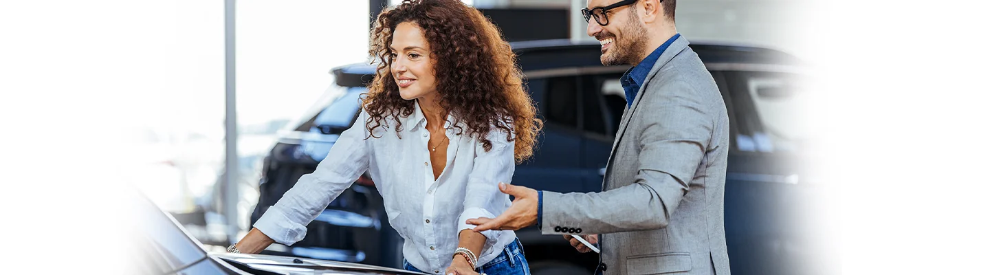 Auto salesman showing vehicle to customer