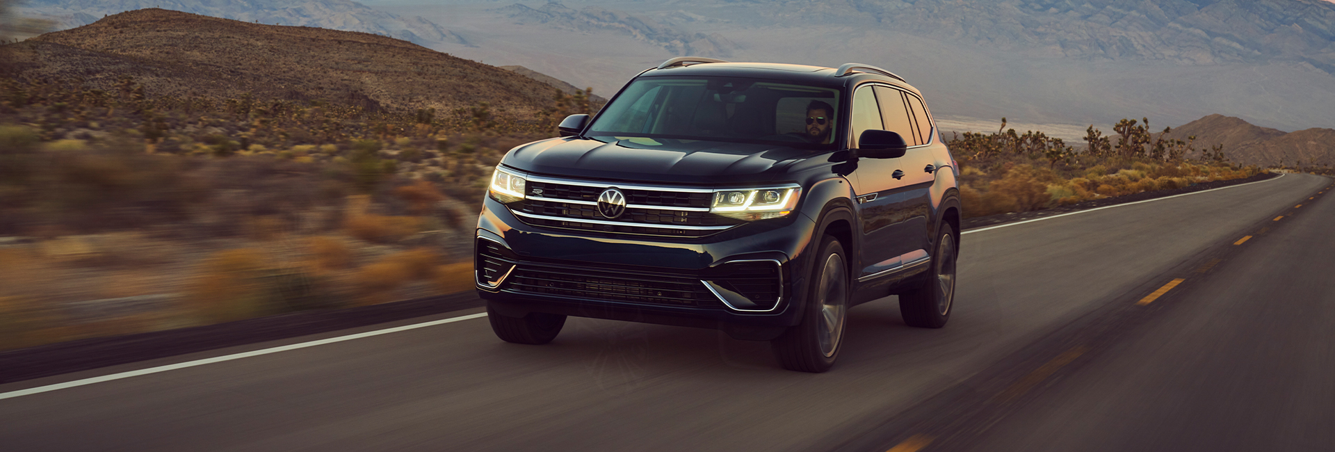 A man driving a 2021 Volkswagen Atlas through the desert