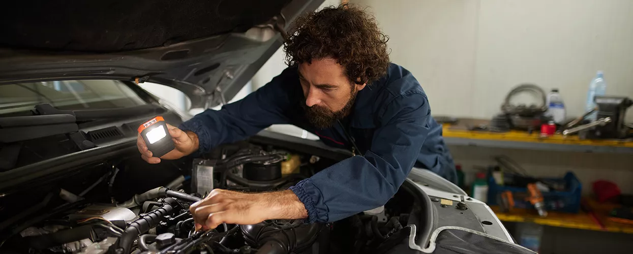 Volkswagen technician performing routine maintenance in a service bay