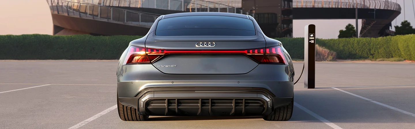 Rear view of a gray 2024 Audi Q4 e-tron Premium at a chraging station