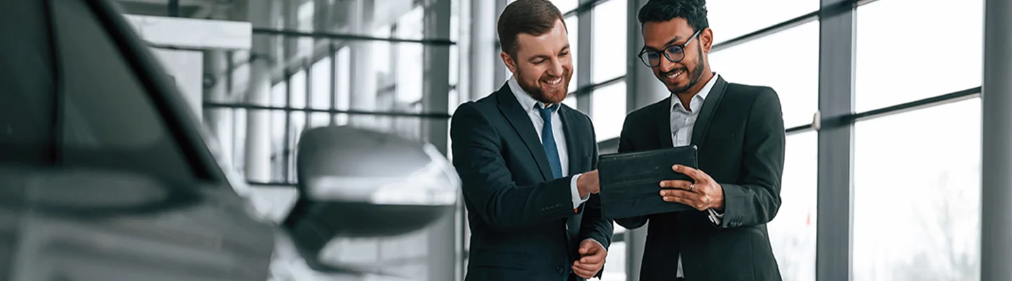 Two auto dealers looking at a tablet