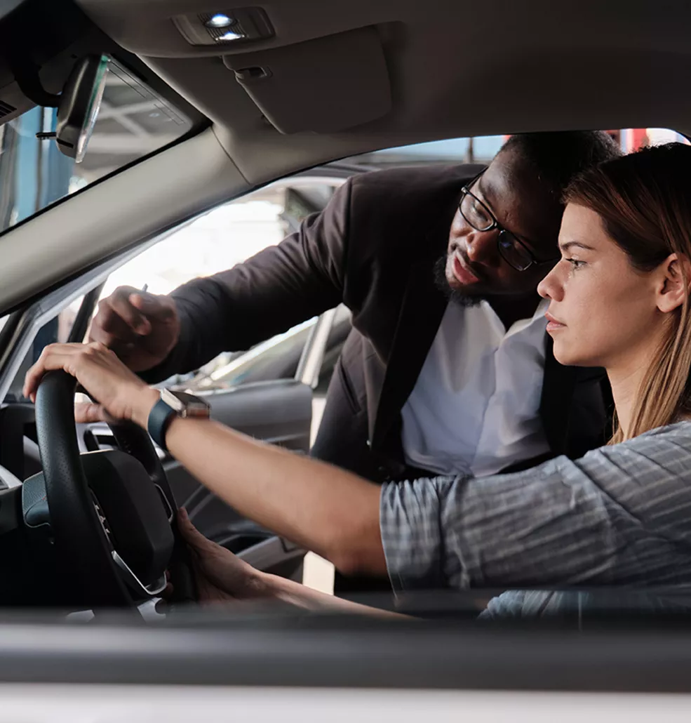 Car salesman showing a customer the inside of a vehicle