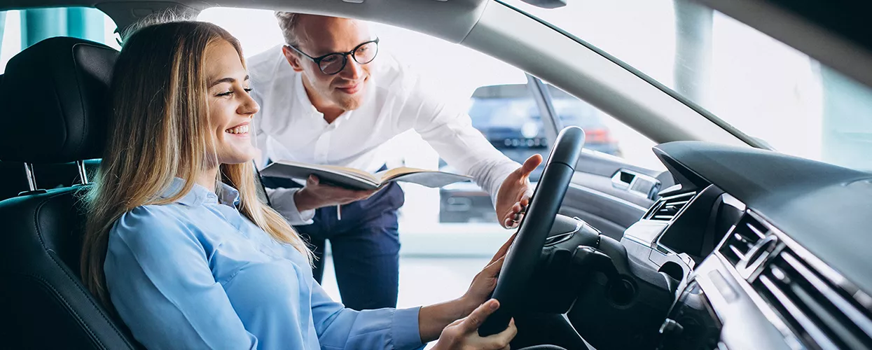 Car salesman showing a customer the interior of a vehicle
