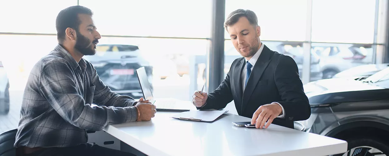 Car salesman talking to customer about a contract