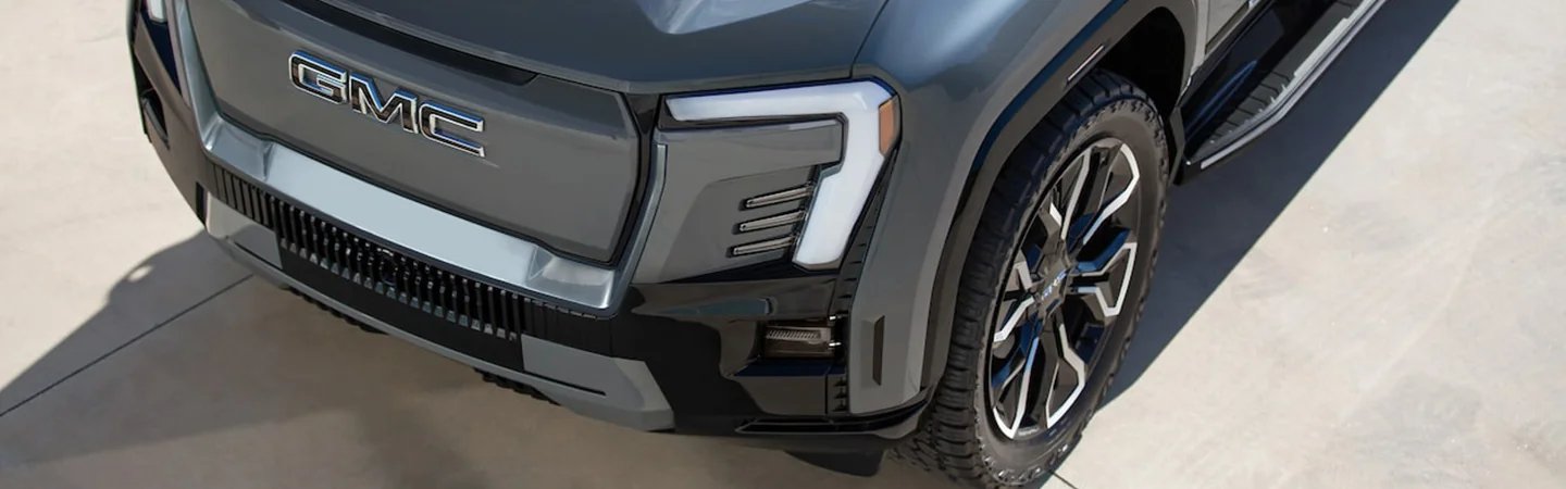View of the grill and tire of a 2024 GMC Sierra EV Denali Edition 1