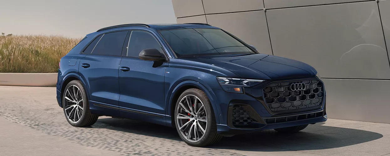 a blue 2026 Audi Q8 parked by a modern building