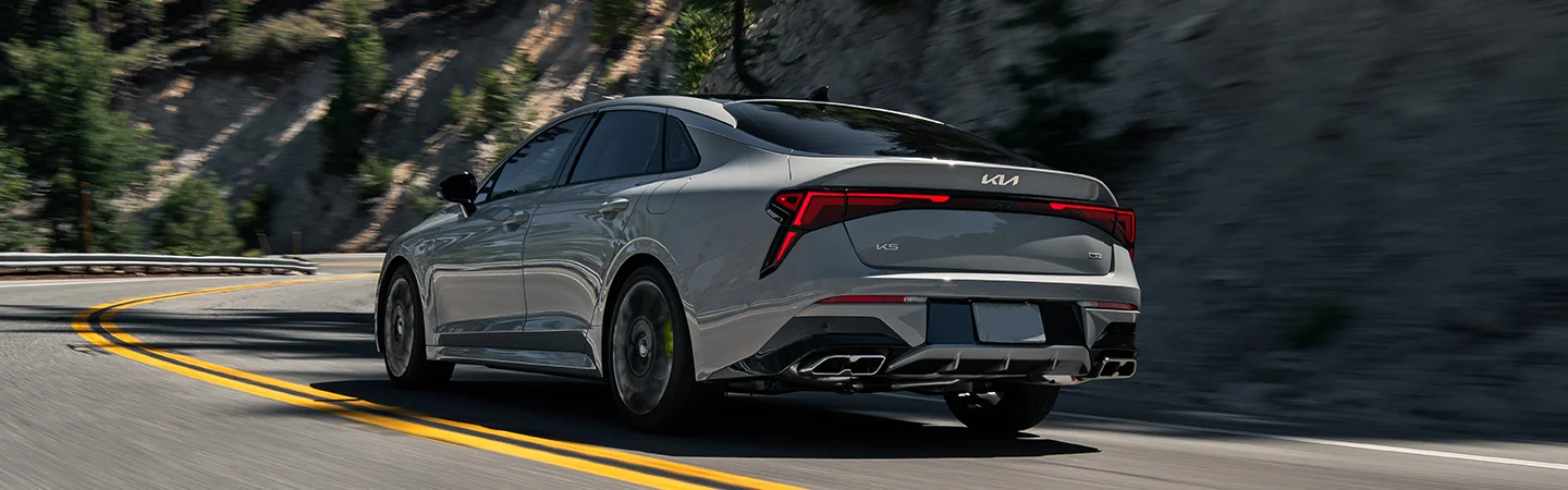 2025 Kia K5 driving on highway back view