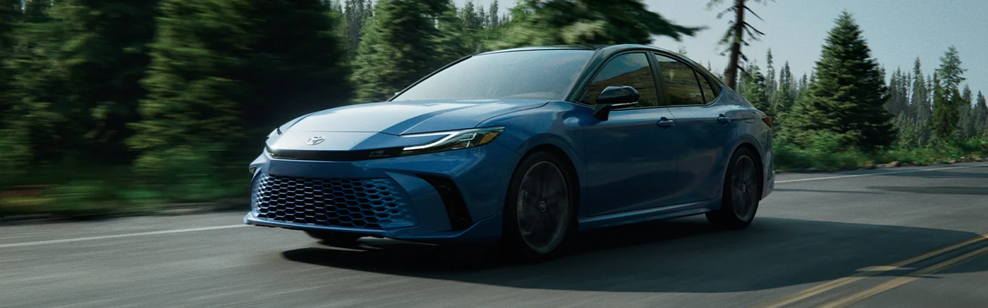 blue 2025 Kia K5 driving on highway