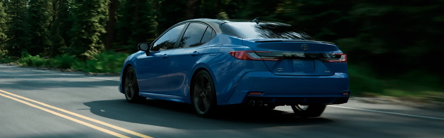 blue 2025 Kia K5 driving on highway back view