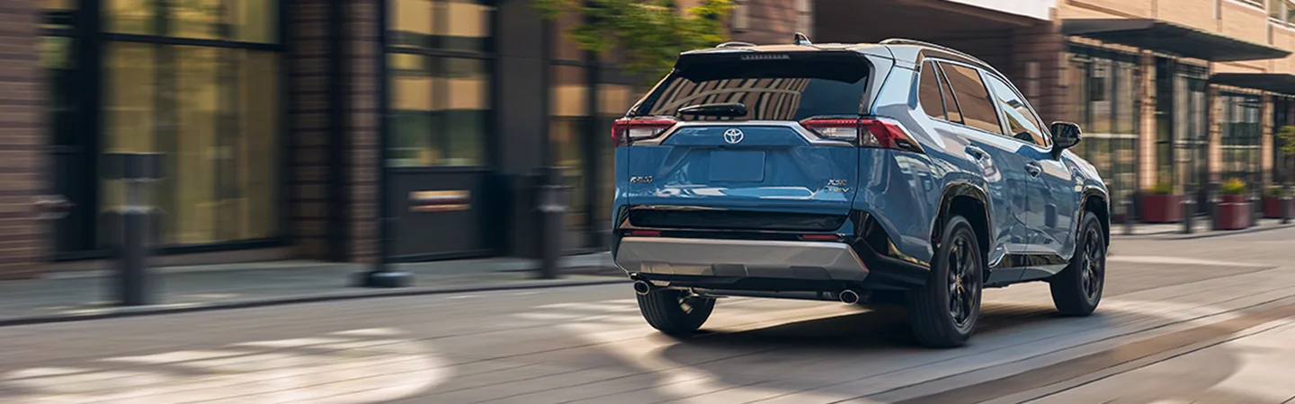 rear view in motion 2025 Toyota RAV4 LE drving down city street