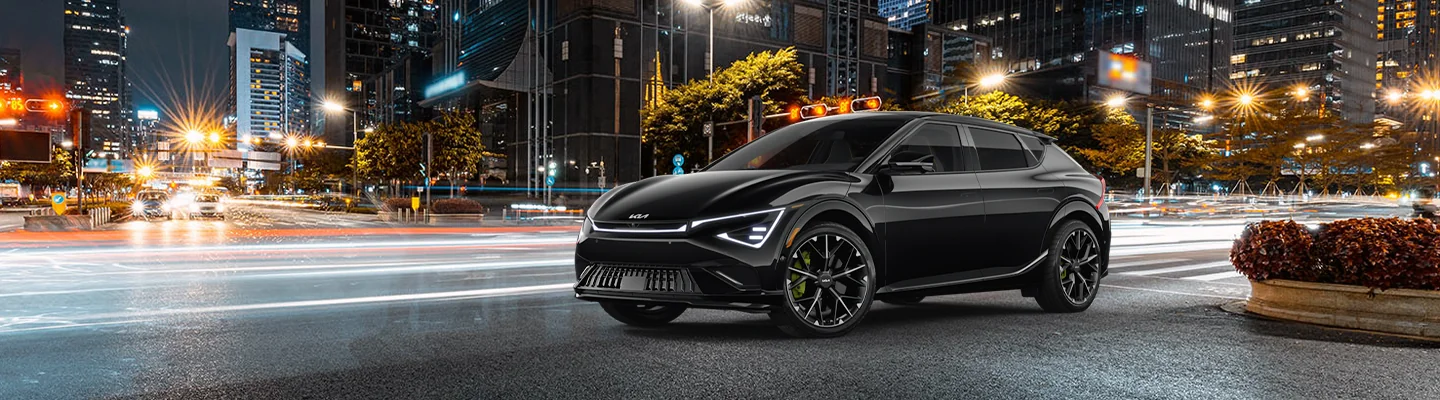 2025 Kia EV6 driving on a city street with lights in the background