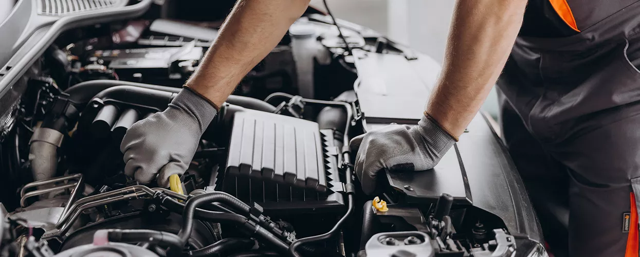 Service mechanic working under the hood of a car