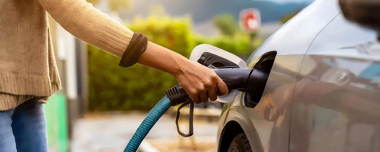 Woman placing EV charger into her car