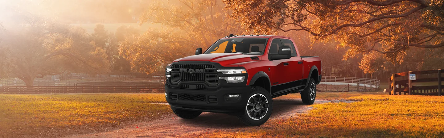 Front side view of a red 2025 RAM 2500 parked on a darm dirt road