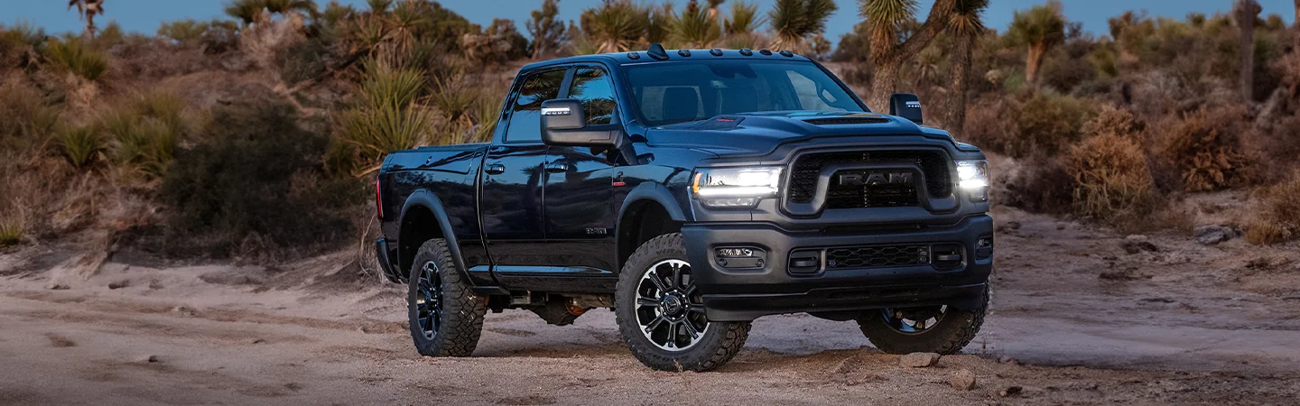 Side view of a black 2025 RAM 2500 on sand dunes