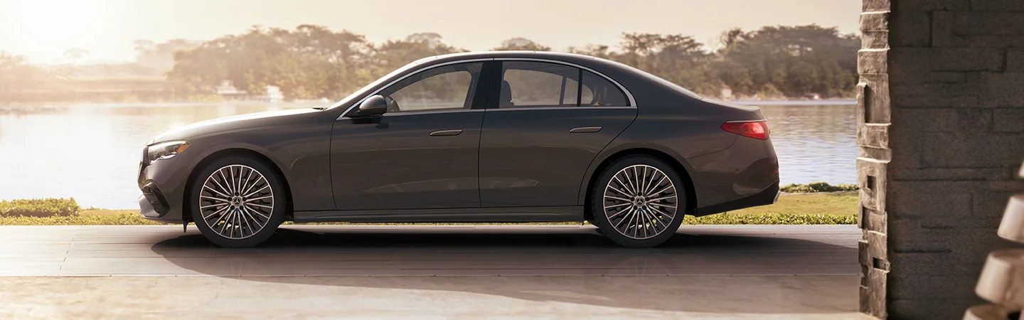 Side view of the 2025 Mercedes-Benz E-Class parked in front of a lake