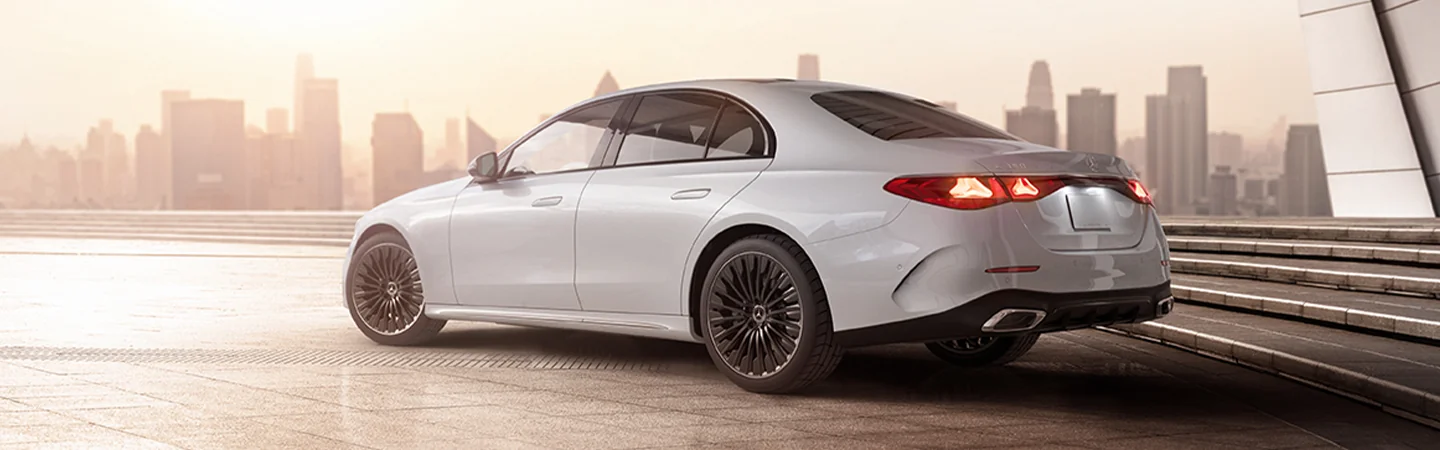 Rear view of the 2025 Mercedes-Benz E-Class parked in front of a city skyline