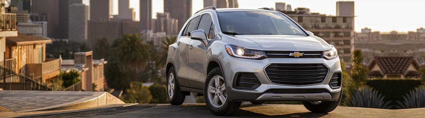 Angled front profile of a parked white Chevy Trax overlooking a city