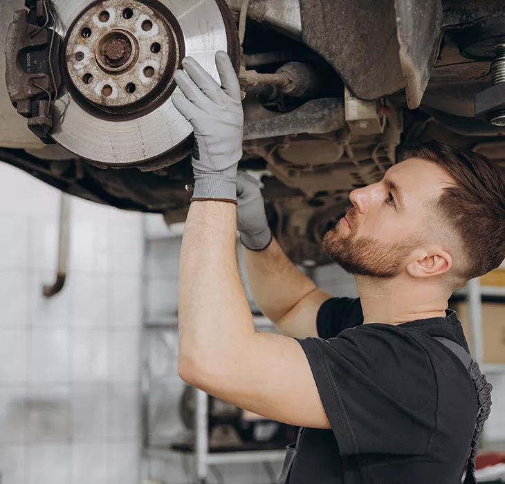 mechanic in the shop room running a diagnosis of a vehicle on the computer