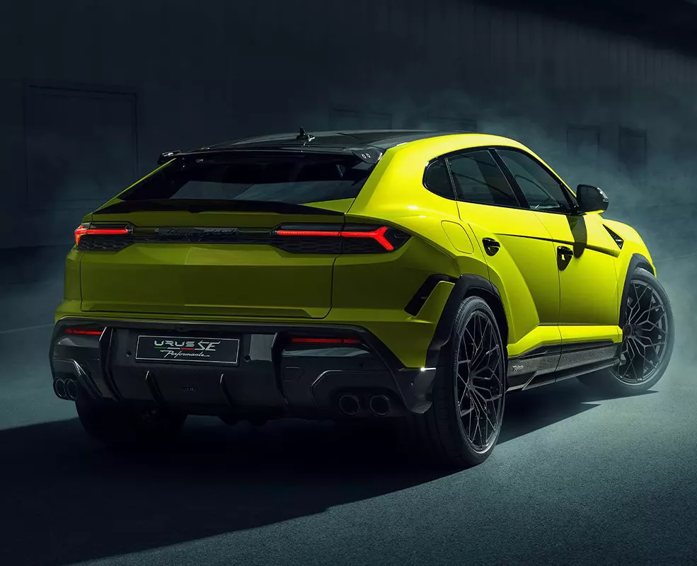 Back view of a 2026 Lamborghini Urus SE turning around a warehouse
