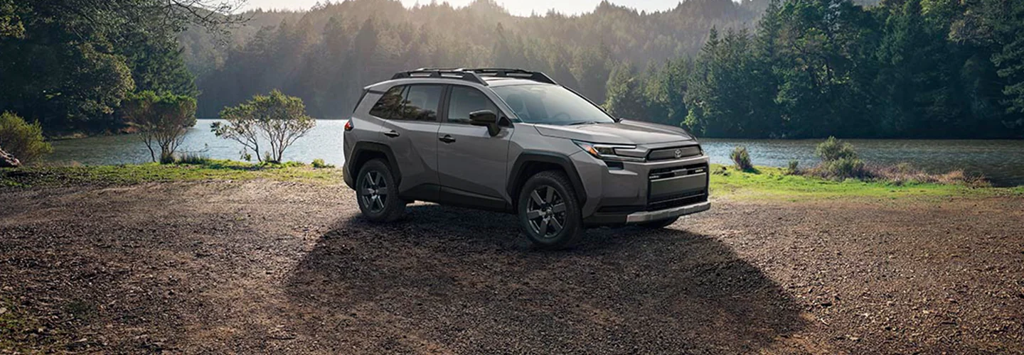 2020 Chevrolet Trailblazer parked on a dirt road beside a serene lake surrounded by trees.