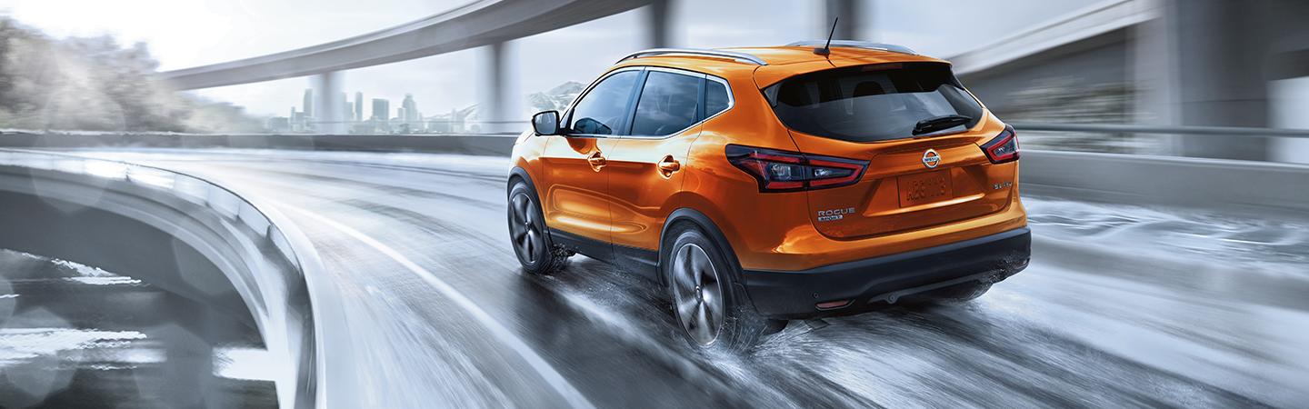 Orange 2021 Nissan Rogue driving on the freeway