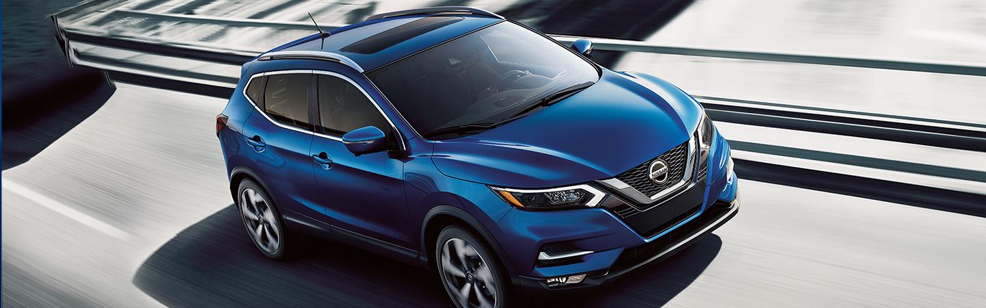 Blue 2021 Nissan Rogue driving on the road